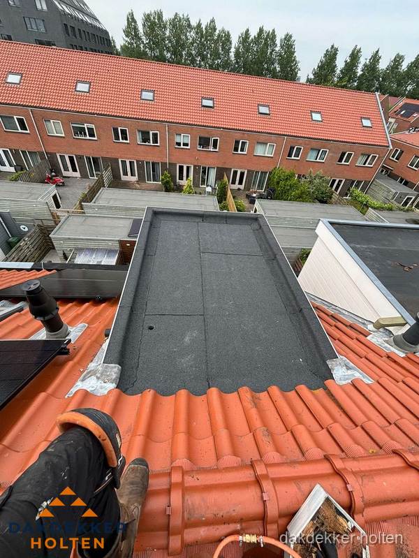 Bitumen dak reparatie op plat dak tussen dakpannen in Holten