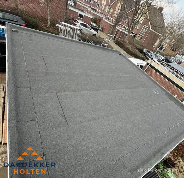 Nieuwe bitumen dakbedekking op plat dak van garage in Holten