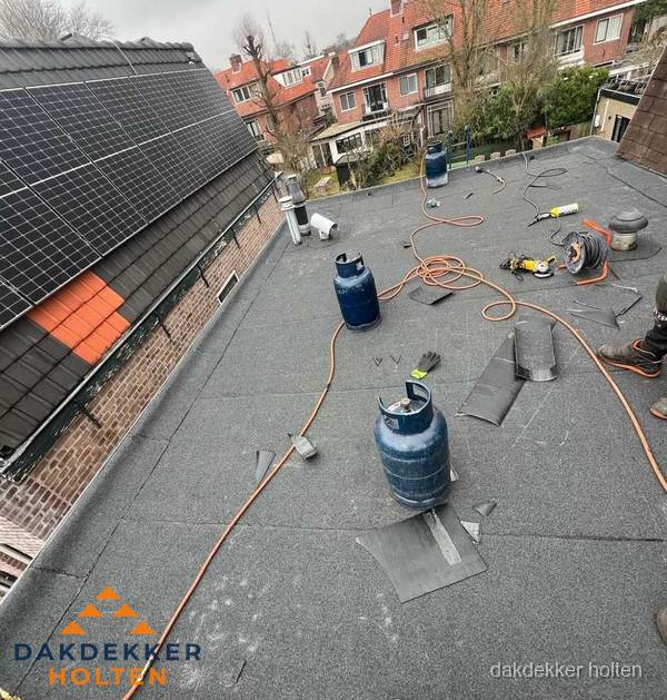 Daklekkage repareren met brandgereedschap op plat dak in Holten
