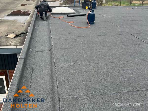 Dakdekker repareert bitumen dakbedekking op groot plat dak in Holten Dakdekker repareert bitumen dakbedekking op groot plat dak in Holten