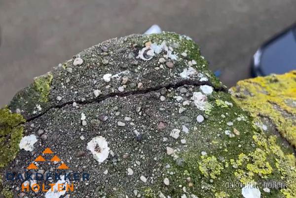 Beschadigde en verweerde nokvorst met scheuren en mos in Holten