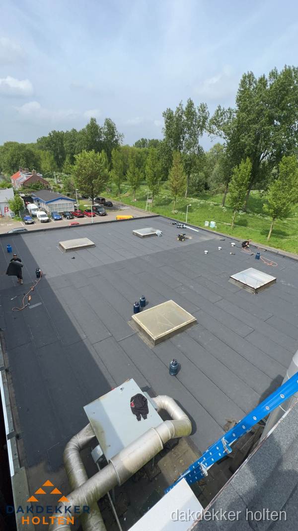 Dakdekker aan het werk op groot plat dak met bitumen in Holten Dakdekker aan het werk op groot plat dak met bitumen in Holten