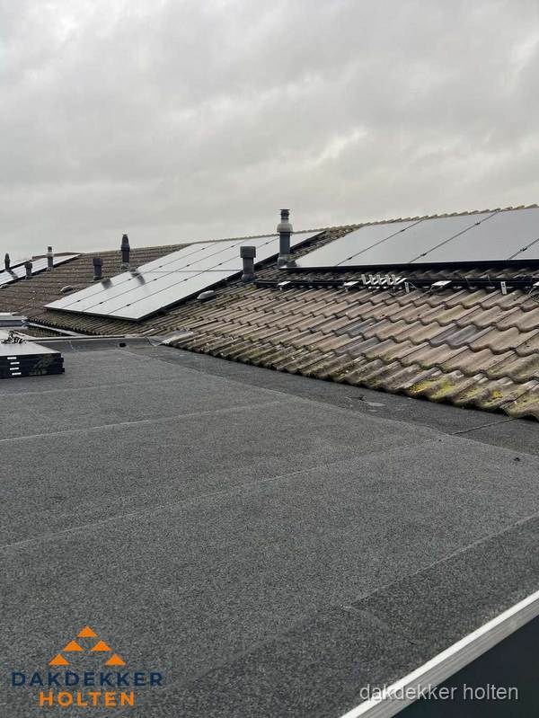 Bitumen dakbedekking op plat dak met aansluitend pannendak en zonnepanelen in Holten