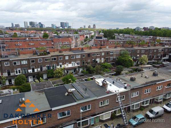 Spoed dakdekker aan het werk op plat dak in woonwijk Holten
