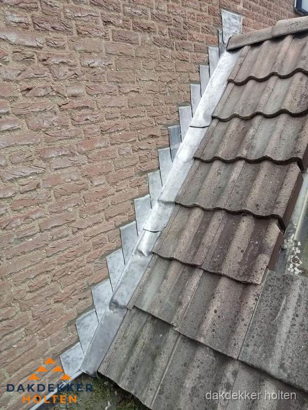 Loodslabben langs dakaansluiting bij bakstenen muur in Holten