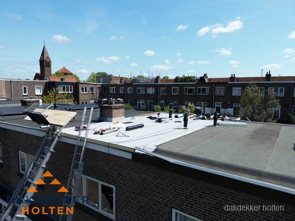 Dakdekkers aan het werk op plat dak in Holten