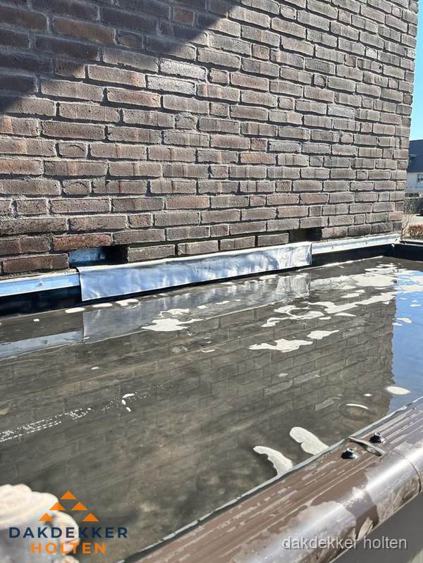 Stilstaand water op plat dak door slechte afwatering in Holten