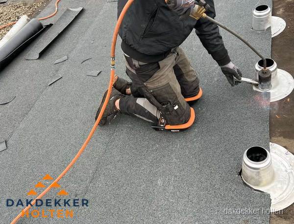 Dakdekker repareert bitumen dakleer bij dakdoorvoer in Holten
